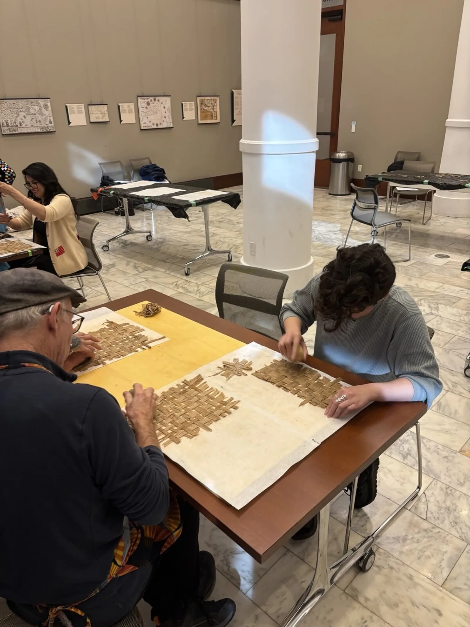 Patron uses rock to hit their woven fibers into amate